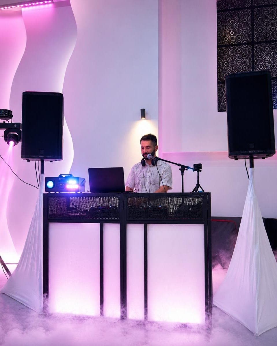 Veysel Durmuş an seinem beleuchteten DJ-Pult, Bodennebel und Lichtstimmung im Saal